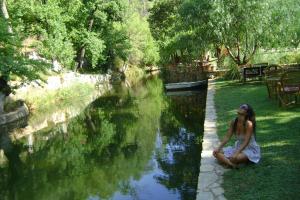 a woman sitting on the grass next to a river at Dalya Life in Göcek