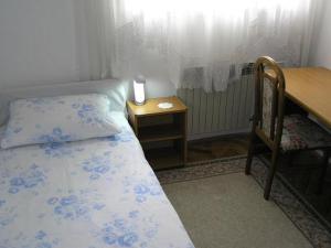 a bedroom with a bed and a table and a desk at Apartments Maximir in Zagreb