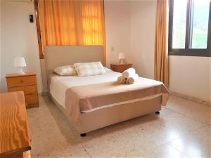 a bedroom with a bed with two towels on it at Ampelokipi Holiday Apartments in Pissouri
