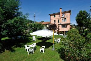 a group of chairs and an umbrella in front of a building at Hotel Villa Mon Toc in Stresa
