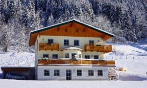 ein Haus im Schnee mit schneebedeckten Bäumen in der Unterkunft Appartement Tauernhof in Kleinarl
