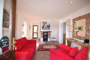 un soggiorno con divani rossi e camino di Inishclare Cottages a Killadeas