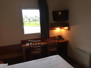 sypialnia z biurkiem z 2 krzesłami i oknem w obiekcie Armony Hotel w mieście Bourg-Achard
