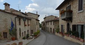 uma rua vazia numa cidade velha com edifícios de pedra em "La Casa di Maria Luce" con terrazza panoramica em Gaiole in Chianti