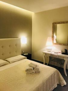 een slaapkamer met een bed met twee handdoeken erop bij Gemini Suite in Rome