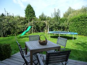 a picnic table with two chairs and a playground at B&B Le Coquin in Bruges