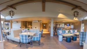 a restaurant with tables and chairs in a room at The Grand at Grasmere in Grasmere