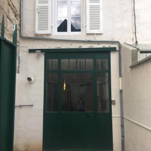 une porte verte sur le côté du bâtiment dans l'établissement Le Lodge centre 400m gare wifi linge de pressing, à Niort