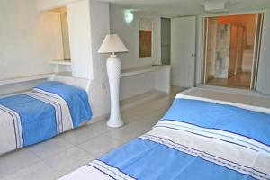 a bedroom with two beds and a lamp in it at Acapulco Villa Brisas 26 in Acapulco