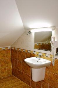 La salle de bains est pourvue d'un lavabo et d'un miroir. dans l'établissement Family Hotel Miglena, à Govedartsi