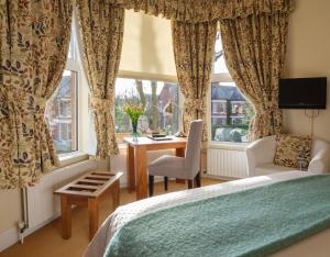 1 dormitorio con cama, escritorio y ventana en Roseleigh House, en Belfast