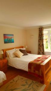 een slaapkamer met een groot bed en een raam bij The Oak at Dewlish in Dorchester