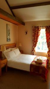 a bedroom with a large bed and a window at The Oak at Dewlish in Dorchester +7 photos