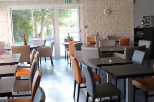サン・ジャン・ド・ヴェダにあるThe Originals City, Le Mas de Grille, Montpellier Sudの窓のあるレストラン(テーブル、椅子付)