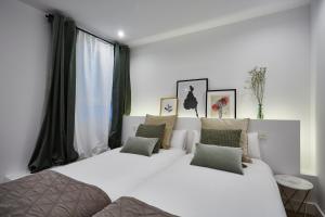 マドリードにあるApartamento junto a Plaza Mayorのベッドルーム1室(ベッド2台、大きな窓付)