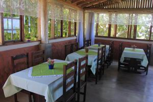 a row of tables in a restaurant with windows at Pousada Vista Bela in Guarapari