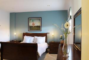 1 dormitorio con cama y pared azul en Castledale en Sligo