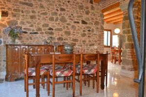 uma sala de jantar com uma mesa e uma parede de pedra em Ca' Tobia em Teolo