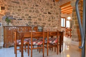 a dining room with a table and a stone wall at Ca' Tobia in Teolo