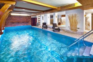 a large swimming pool with blue water in a house at Kneipp-Kurhotel Steinle in Bad Wörishofen