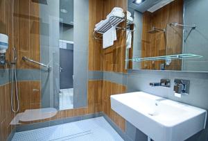 W łazience znajduje się umywalka i prysznic. w obiekcie Hotel Kozak w mieście Chełm