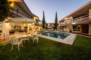 a backyard with a pool and a table and chairs at Quinta Rivera Hotel in Actopan
