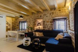 een woonkamer met een blauwe bank en een tafel bij Apartment Capo Family & Capo Studio -Old Town-Parking in Trogir