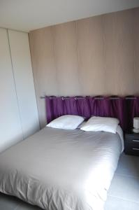 Rouffignac Saint-CerninにあるLa rousselieの白いベッド(紫色のヘッドボード、枕2つ付)