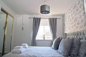 Schlafzimmer mit einem Bett vor einem Fenster in der Unterkunft No5 Ayr Beach - Coorie Doon Stays in Ayr