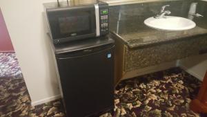 a microwave sitting on top of a counter next to a sink at Flamingo Inn Long Beach in Long Beach