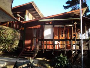 a wooden house with a porch at Villa Los Lobos in El Quisco