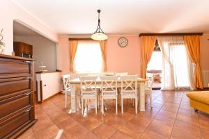 a dining room with a white table and chairs at Apartment Modrusani 1561 in Žminj