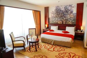 a hotel room with a bed and a table and chair at City Inn Palace Hotel in Ramallah