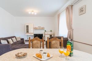 a table with two glasses of orange juice on it at Apartman Tea in Privlaka