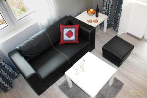 a living room with a black leather couch and a table at The Yellow House in Sofia in Sofia