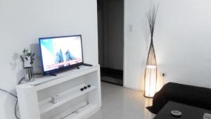 una sala de estar con TV en una cómoda blanca en Departamento de Jerarquía en Recoleta en Buenos Aires