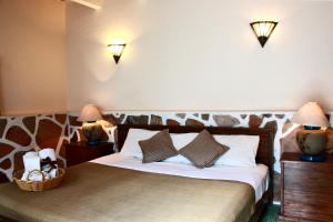 ein Schlafzimmer mit einem Bett mit zwei Lichtern an der Wand in der Unterkunft Casa Blanca Tequisquiapan in Tequisquiapan