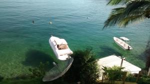 two boats are docked at a dock in the water at Casa Na Ilha Grande De Frente Pro Mar Com Pier in Angra dos Reis