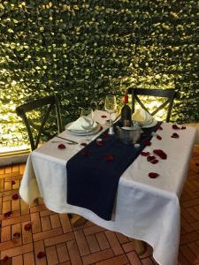 a table with wine glasses and red roses on it at El Hotel Business Class in Zamora de Hidalgo