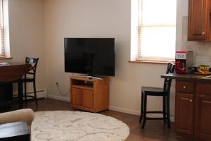 a living room with a flat screen tv on a stand at Attractive East Hill Apartment in Ithaca