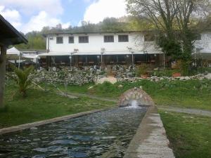 a small bridge over a pond in front of a house at Agriturismo Le Cannucceta in Castel San Pietro Romano