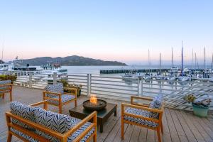 a patio with chairs and a table with a fire pit at Waters Edge in Tiburon