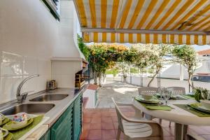 a kitchen with a sink and a table with chairs at Bougainvilleas Villa - Private Pool and Parking, Nearby Beach in Altura