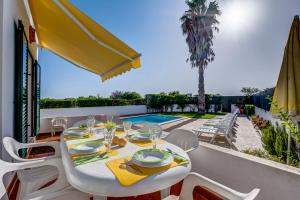 a table and chairs on the balcony of a house at Bougainvilleas Villa - Private Pool and Parking, Nearby Beach in Altura