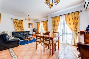 a living room with a table and chairs and a couch at Bougainvilleas Villa - Private Pool and Parking, Nearby Beach in Altura