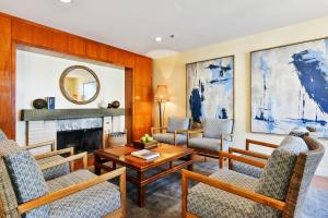 a living room with chairs and a fireplace at Waters Edge in Tiburon