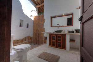 a bathroom with a toilet and a sink and a mirror at Casa Bari La Antigua in Barichara +31 photos