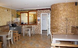 a kitchen with a table, chairs and a refrigerator at Mini-Hotel Coral Family in Mostovskoy