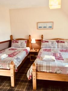 two beds sitting next to each other in a bedroom at Glengorm Guest House in Oban