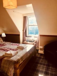 a hotel room with a bed and a window at Glengorm Guest House in Oban